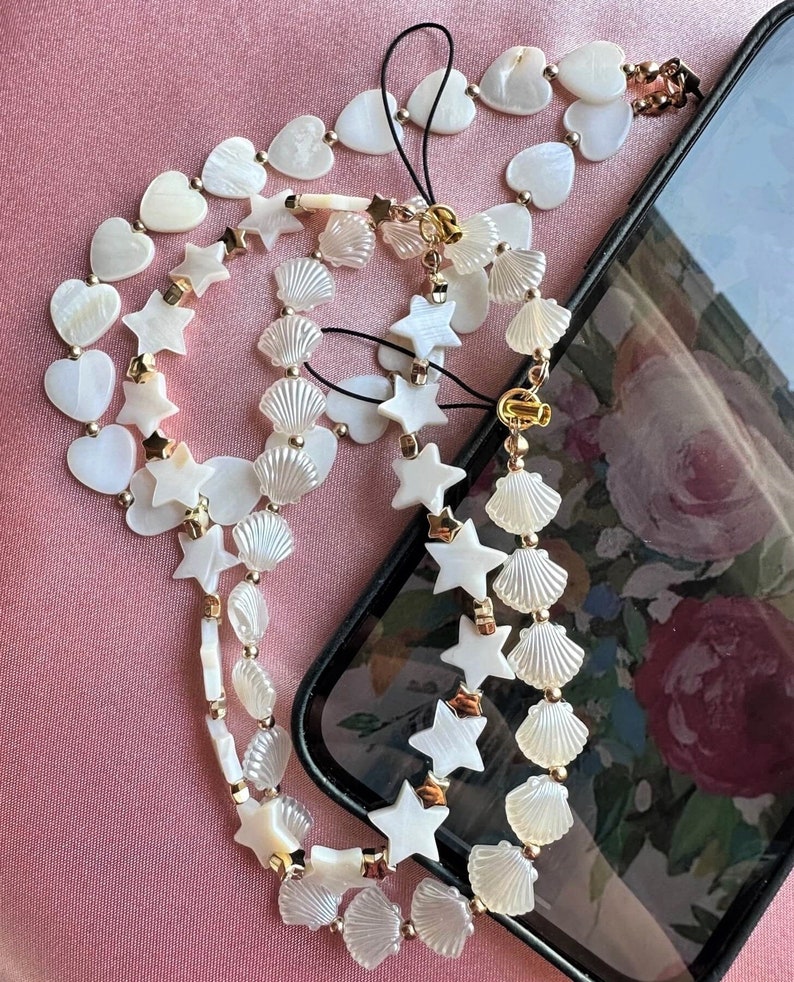 Mother of pearl phone charm chains.  Heart shaped mother of pearl beaded phone charm chains for hands free phone use.  Mobile phone accessories.
Star shaped mother of pearl phone charm chain.
Seashell mobile phone charm.
Mobile phone lanyard.