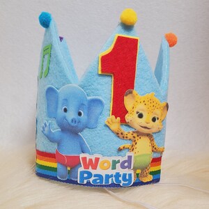 May include: Blue felt crown with a red felt number one, a yellow felt star, and a rainbow stripe. The crown features images of characters from the show Word Party, including a blue elephant and a yellow cheetah. The crown says "Word Party" on the front.