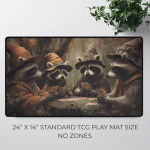 K&ouml;nnte beinhalten: Rechteckige Spielmatte mit vier Waschb&auml;ren in Zaubererh&uuml;ten, die Karten spielen. Die Matte ist 61 cm x 36 cm gro&szlig; und tr&auml;gt am unteren Rand den Text "STANDARD TCG PLAY MAT SIZE" und "NO ZONES".