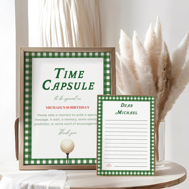May include: A framed sign with the words "Time Capsule" in green, with a golf ball illustration. A smaller card reads "Dear Michael." Both have green and white checkered borders. The sign is for Michael's 18th birthday.