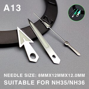 May include: Silver watch hands with luminous green accents. The set includes an arrow-shaped hour hand, a rectangular minute hand, and a slender second hand. The text "A13" is visible. The text "NEEDLE SIZE: 8MMX12MMX12.0MM SUITABLE FOR NH35/NH36" is also visible.