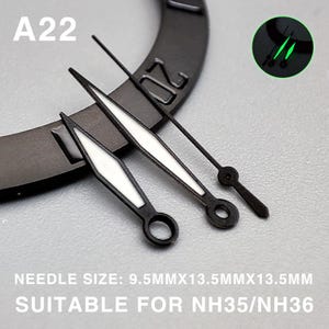 Op de afbeelding: Close-up van horlogewijzers met een zwarte afwerking en witte lichtgevende accenten. De afbeelding bevat de tekst "A22" en "NEEDLE SIZE: 9.5MMX13.5MMX13.5MM SUITABLE FOR NH35/NH36".