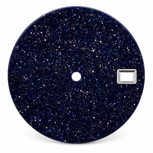 Peut inclure: Un cadran de montre circulaire en verre aventurine bleu foncé avec un motif scintillant rappelant des étoiles. Le cadran présente un trou central circulaire pour les aiguilles et un cadre rectangulaire pour la date sur le côté droit.
