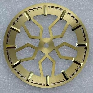 Pode incluir: Mostrador de rel&oacute;gio dourado com um design geom&eacute;trico complexo. Possui marcadores retangulares e linhas finas para medi&ccedil;&atilde;o do tempo. O centro tem um orif&iacute;cio e o design &eacute; intrincado e detalhado.