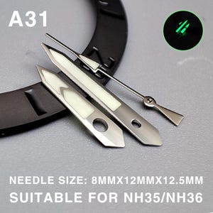 Op de afbeelding: Set horlogewijzers met een lichtgevend wit midden en zilverkleurig metaal. De set bevat uur-, minuten- en secondewijzers. De tekst "A31" is zichtbaar. De tekst "NEEDLE SIZE: 8MMX12MMX12.5MM SUITABLE FOR NH35/NH36" is ook zichtbaar.