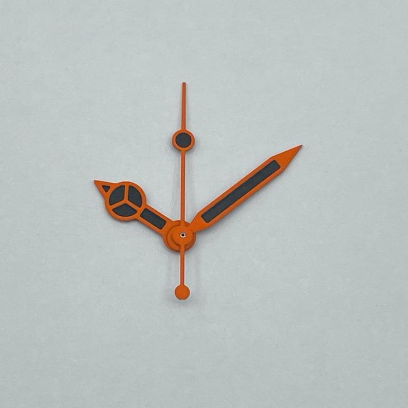 May include: Orange and black watch hands against a light gray background. The hands include a minute hand, an hour hand, and a second hand. The hour hand has a black rectangle in the middle. The minute hand has a black circle. The second hand has a black circle and a small dot.