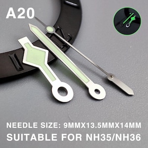 Op de afbeelding: Close-up van horlogewijzers met een lichtgevende groene gloed. De wijzers zijn zilverkleurig met een groene lichtgevende vulling en zijn gemarkeerd met "A20". De tekst onderaan luidt "NEEDLE SIZE: 9MMX13.5MMX14MM SUITABLE FOR NH35/NH36".