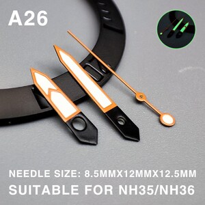 Op de afbeelding: Set horlogewijzers met zwarte, oranje en witte accenten. De set bevat uur-, minuten- en secondewijzers. De tekst "A26" is zichtbaar. De tekst "NEEDLE SIZE: 8.5MMX12MMX12.5MM SUITABLE FOR NH35/NH36" is ook zichtbaar.