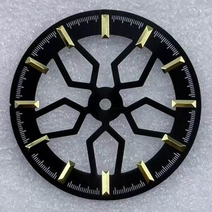 Pode incluir: Um mostrador de rel&oacute;gio preto com marcadores de hora dourados e um design geom&eacute;trico. O mostrador &eacute; circular com pequenas linhas na borda para as indica&ccedil;&otilde;es dos minutos. Os marcadores dourados s&atilde;o retangulares e espa&ccedil;ados. O di&acirc;metro &eacute; de cerca de 3,5 cm.