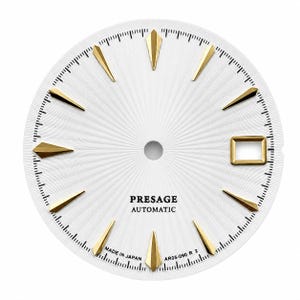 Puede incluir: Una esfera de reloj circular blanca con una superficie texturizada en rayos de sol, marcadores de hora dorados facetados y una ventana de fecha rectangular en la posición de las tres. El texto PRESAGE AUTOMATIC, MADE IN JAPAN y AR05-090 R 2 está impreso en negro.