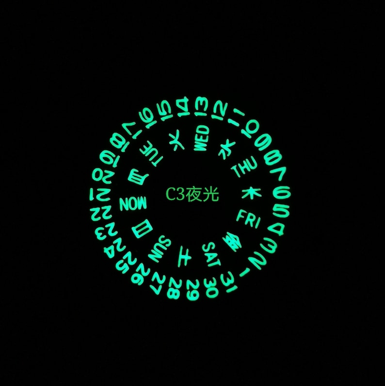 May include: A circular watch face with glow-in-the-dark numbers and days of the week in English and Japanese. The text "C3 夜光" is in the center of the watch face.