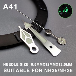 May include: A collection of watch hands in various styles, including a long, thin second hand and hands with geometric shapes. The hands are silver-toned with a luminous, light green glow. Text on the image reads "A41" and "NEEDLE SIZE: 8.5MMX12MMX12.5MM SUITABLE FOR NH35/NH36."