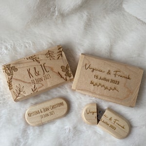 Peut inclure: Trois clés USB en bois avec du texte gravé et des motifs floraux. Les clés USB sont en forme de rectangle, de rectangle arrondi et de cercle. Le texte sur les clés USB indique "K&JC 10 JUIN 2023", "Virginie & Franck 15 Juillet 2023" et "Krystina & Jean-Christophe 10 JUIN 2023".