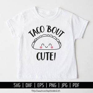 May include: White t-shirt with a black and white illustration of a smiling taco with the text "Taco 'Bout Cute!" printed on it.