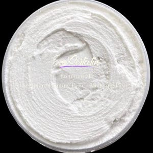 May include: A circular container filled with white, thick, textured modeling paste. The surface shows visible swirl marks from application. The text EzySertcetin Premium 3D Sculpture Painting Paste Modeling Paste is printed in white across the center.