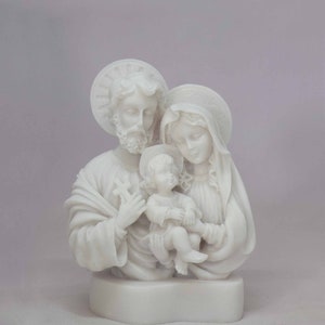 Peut inclure: Sculpture en alb&acirc;tre blanc de la Sainte Famille. La sculpture repr&eacute;sente Marie, Joseph et l'enfant J&eacute;sus. La sculpture est une repr&eacute;sentation traditionnelle de la Sainte Famille.