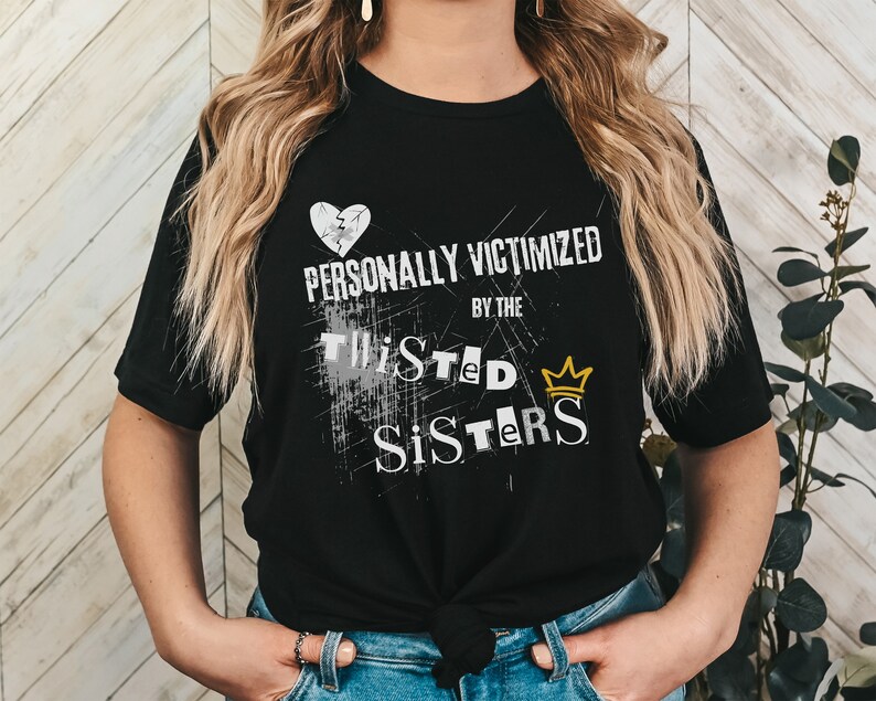 May include: Black t-shirt with a white broken heart, the text "PERSONALLY VICTIMIZED BY THE TWISTED SISTERS" and a gold crown.