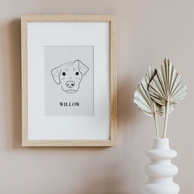 May include: A framed print of a dog's head with the name "Willow" printed below. The dog is drawn in a simple line art style.