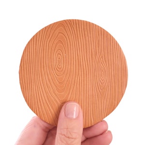May include: A round, brown coaster with a wood grain pattern.