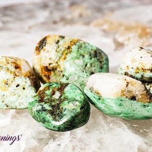 May include: Five green, white, and brown tumbled stones. The stones are smooth and have a natural, organic look.