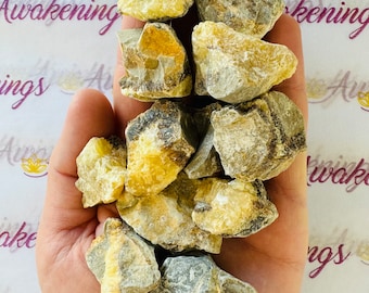 May include: A collection of rough, natural Selenite crystals. The crystals are a mix of white and yellow, with some having a translucent quality. The crystals are in various shapes and sizes.