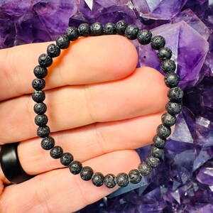 Peut inclure: Un bracelet en perles de lave noire. Le bracelet est composé de petites perles rondes avec une surface rugueuse et texturée.