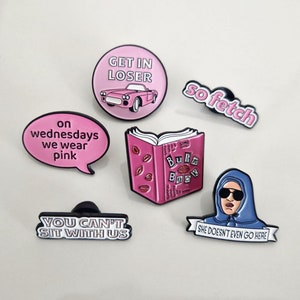 Puede incluir: Conjunto de seis pines de esmalte con citas e im&aacute;genes populares de la pel&iacute;cula Mean Girls. Los pines son de color rosa, blanco y azul con contornos negros. Los pines presentan el texto "Get in Loser", "On Wednesdays We Wear Pink", "You Can't Sit With Us", "So Fetch", "Burn Book" y "She Doesn't Even Go Here".