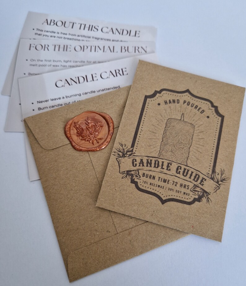 K&ouml;nnte beinhalten: Ein brauner Papierumschlag mit einem Wachssiegel und einer Karte im Inneren. Die Karte zeigt eine Kerzenillustration und den Text "Hand Poured" und "Candle Guide". Der Text auf der Karte lautet au&szlig;erdem "Burn Time: 72 Hrs" und "70% Beeswax | 30% Soy Wax".