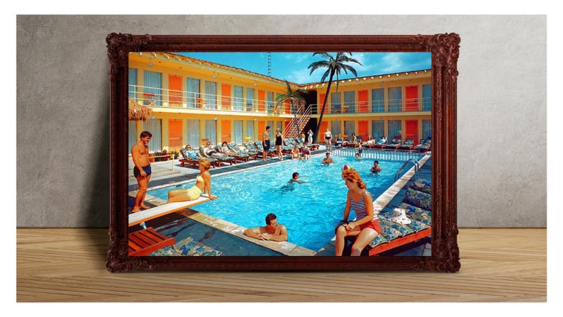 May include: A vintage photograph of a motel pool with people swimming and lounging around the pool. The pool is surrounded by a yellow building with orange accents and palm trees.