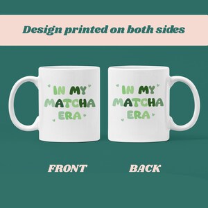 Może przedstawiać: Biały kubek ceramiczny z zielono-białym wzorem, na kt&oacute;rym po obu stronach widnieje napis "In My Matcha Era".