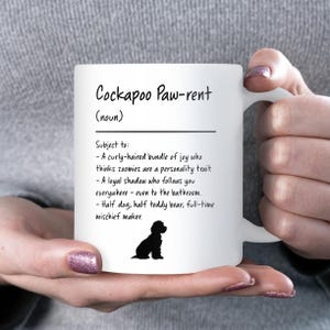 May include: White ceramic mug with the text "Cockapoo Paw-rent (noun)" and a description of a Cockapoo's personality. The mug also features a black silhouette of a Cockapoo dog.