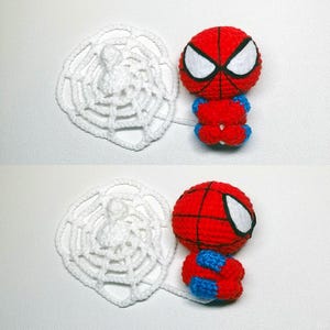 May include: A small, round, crocheted figure featuring a red and blue color scheme with a black web pattern and large white eyes. The figure is attached to a circular, white, crocheted spider web element that extends from its side.