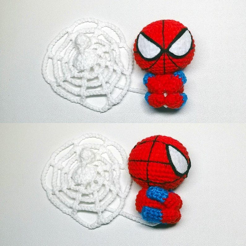 May include: A small, round, crocheted figure featuring a red and blue color scheme with a black web pattern and large white eyes. The figure is attached to a circular, white, crocheted spider web element that extends from its side.