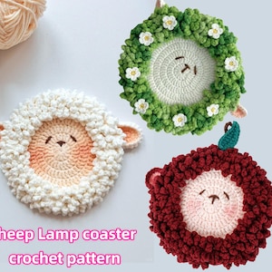 May include: Three crocheted sheep lamp coasters. One is white, one is green with white flowers, and one is red.  The coasters are shaped like sheep with a round face and a fluffy body.  Sheep Lamp Coaster Crochet Pattern.