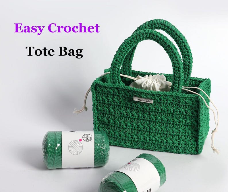 May include: A handmade green crochet tote bag with two handles, a drawstring closure, and a small "handmade" tag. Two rolls of green yarn are in the foreground. The text "Easy Crochet Tote Bag" is in the upper left corner.
