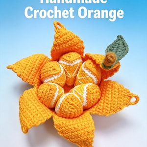 May include: A handmade crochet orange with a peeled rind revealing segmented sections. The orange is bright orange with white detailing on the segments and a single green leaf attached to a brown stem. The text Handmade Crochet Orange is visible.