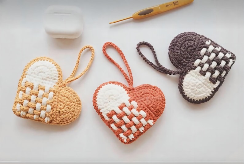 Peut inclure: Trois ornements en forme de c&oelig;ur en crochet avec du fil blanc et marron, blanc et orange et blanc et gris. Les c&oelig;urs ont un motif tiss&eacute;.