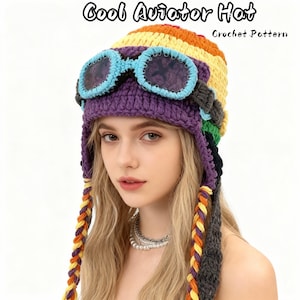 May include: A colorful crochet aviator hat with attached goggles. The hat features a rainbow design with a purple base and blue-rimmed goggles. The text "Cool Aviator Hat" and "Crochet Pattern" are visible.