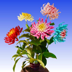 May include: A bouquet of colorful, handcrafted flowers in a dark vase against a blue gradient background. The flowers include red, yellow, pink, and blue blooms with green leaves. The vase is dark brown.
