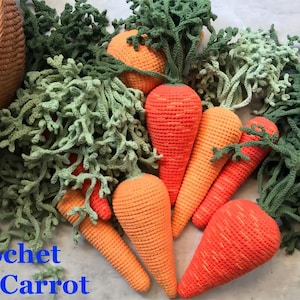 Pode incluir: Cenouras de crochê com folhas verdes. As cenouras são laranja e têm uma superfície texturizada. As folhas são verdes e têm uma textura fofa. As cenouras estão dispostas sobre uma superfície cinza claro. O texto "Crochet Carrot" está escrito em letras azuis na parte inferior da imagem.