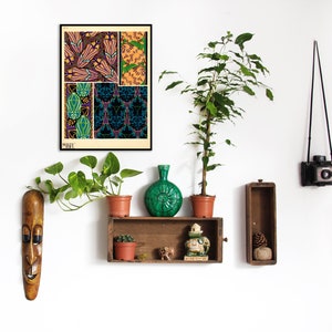 K&ouml;nnte beinhalten: Ein gerahmter Druck mit floralen und geometrischen Mustern in Lila, Gr&uuml;n und Gold. Der Druck h&auml;ngt an einer wei&szlig;en Wand, zusammen mit einem Holzregal mit Topfpflanzen, einer gr&uuml;nen Vase und dekorativen Gegenst&auml;nden. Eine Vintage-Kamera ist ebenfalls zu sehen.