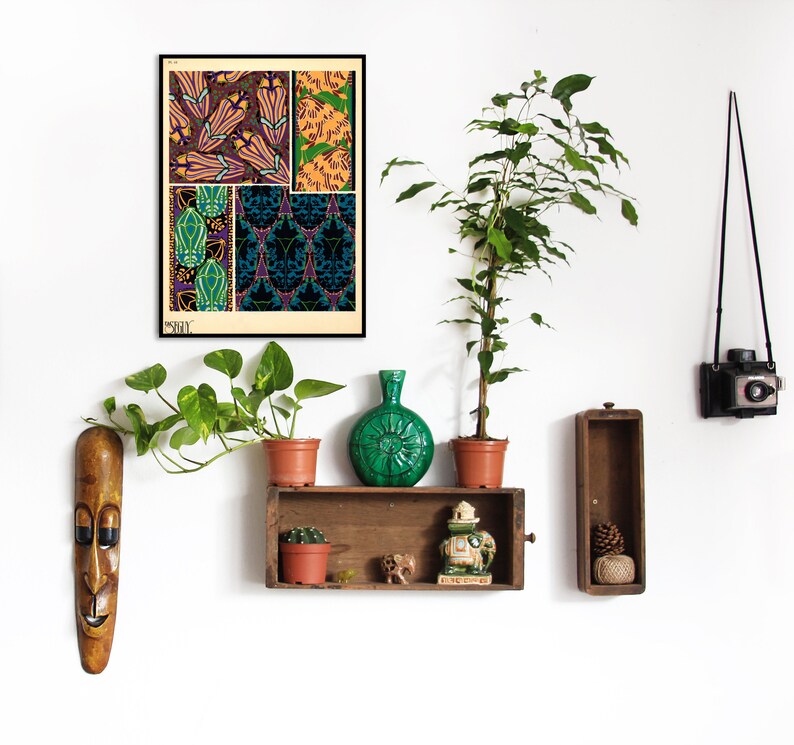 K&ouml;nnte beinhalten: Ein gerahmter Druck mit floralen und geometrischen Mustern in Lila, Gr&uuml;n und Gold. Der Druck h&auml;ngt an einer wei&szlig;en Wand, zusammen mit einem Holzregal mit Topfpflanzen, einer gr&uuml;nen Vase und dekorativen Gegenst&auml;nden. Eine Vintage-Kamera ist ebenfalls zu sehen.