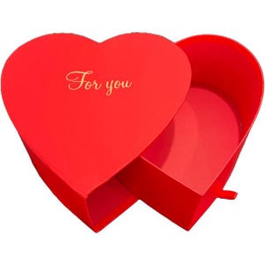 May include: A red heart-shaped gift box with a lid slightly ajar, revealing the interior. The lid has gold script that reads "For you". The box is open, showing the inside. The box is made of a smooth material.