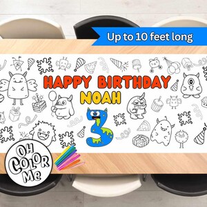 May include: A white table cover with a monster theme, featuring a "Happy Birthday Noah" banner, a number 3, and various black and white outlines of monsters, food, and party hats. The table cover is designed to be colored in with markers or crayons. The text "Oh Color Me" is printed in a circle on the table cover.