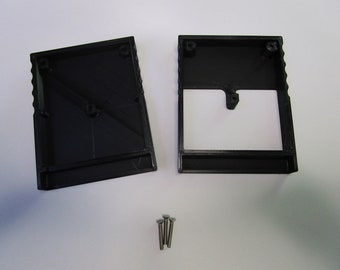 May include: Two black plastic rectangular boxes with a small rectangular opening on one side. The boxes are designed to be joined together. Four small silver screws are included.