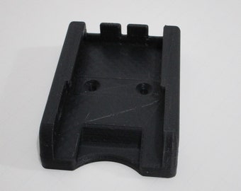 May include: Black plastic phone holder with two screw holes and a slot for a phone.