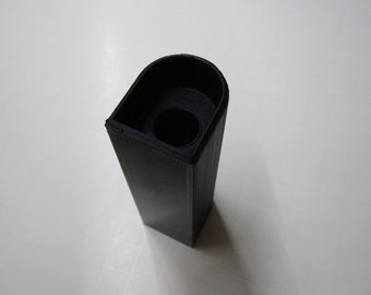 May include: A black plastic 3D printed object with a rounded top and a cylindrical hole in the center.