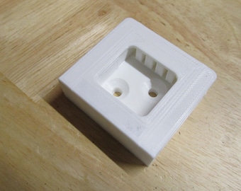 May include: White plastic wall mount with two holes and a rectangular cutout.