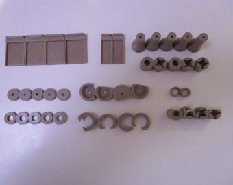 May include: Assortment of brown plastic pieces, including small circles, squares, and other shapes. These pieces are likely for a model or craft project.