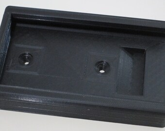 May include: A black plastic 3D printed phone mount with two holes for screws.
